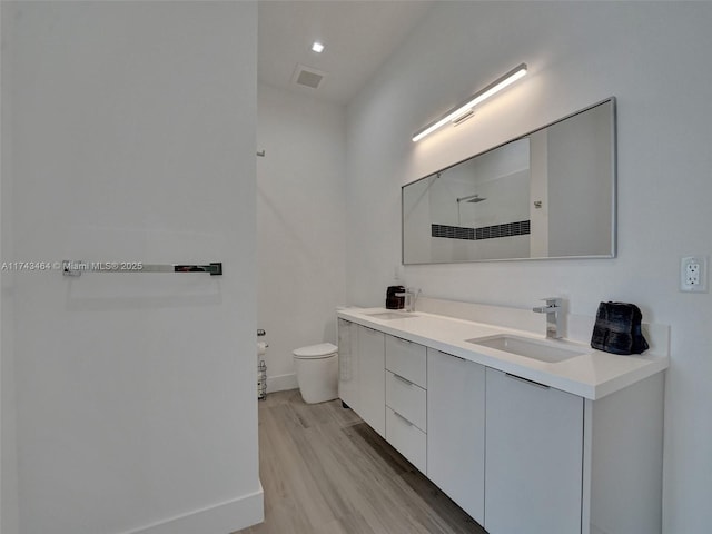 bathroom featuring vanity, toilet, hardwood / wood-style floors, and a shower