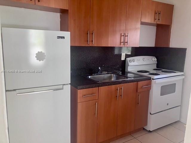 kitchen with sink, white appliances, light tile patterned floors, and backsplash