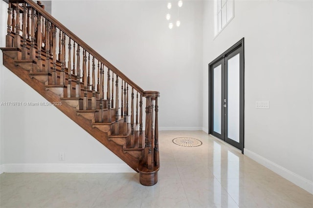 foyer entrance with a towering ceiling and french doors