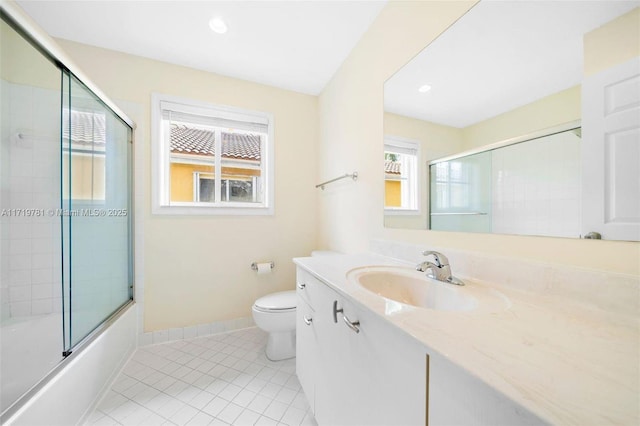 full bathroom featuring vanity, combined bath / shower with glass door, tile patterned floors, and toilet