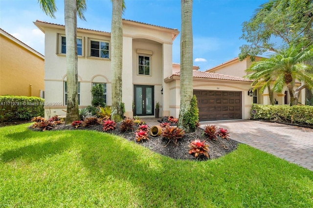 mediterranean / spanish house featuring a garage and a front yard