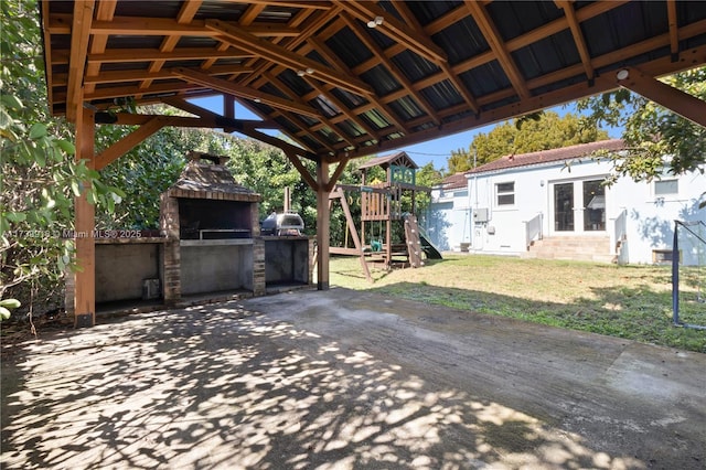 view of patio / terrace featuring a playground, a gazebo, area for grilling, and a fireplace