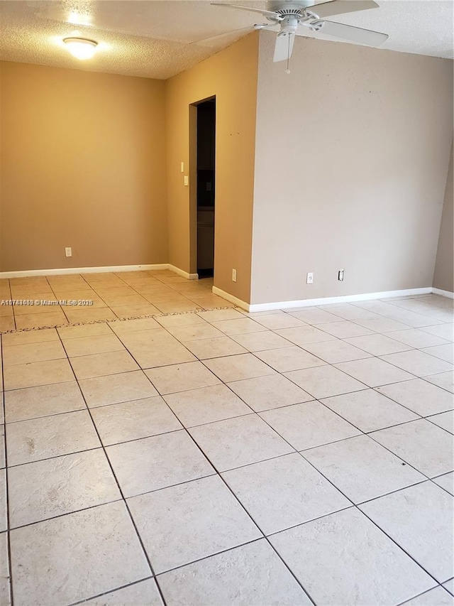 empty room with light tile patterned flooring, ceiling fan, and a textured ceiling