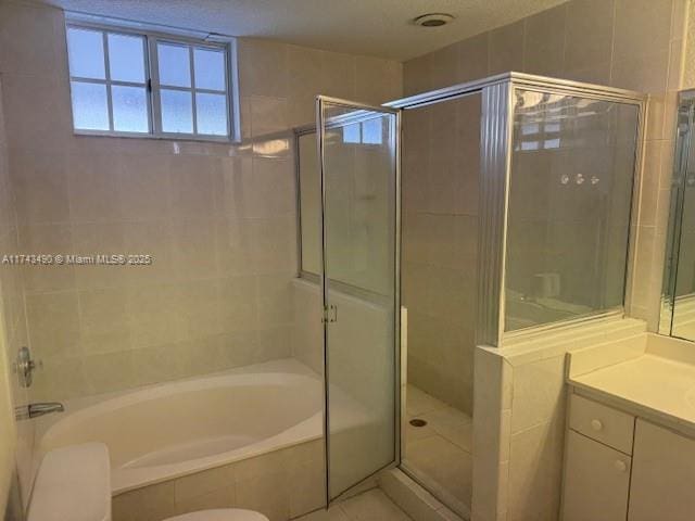 bathroom featuring plus walk in shower, vanity, and tile patterned floors