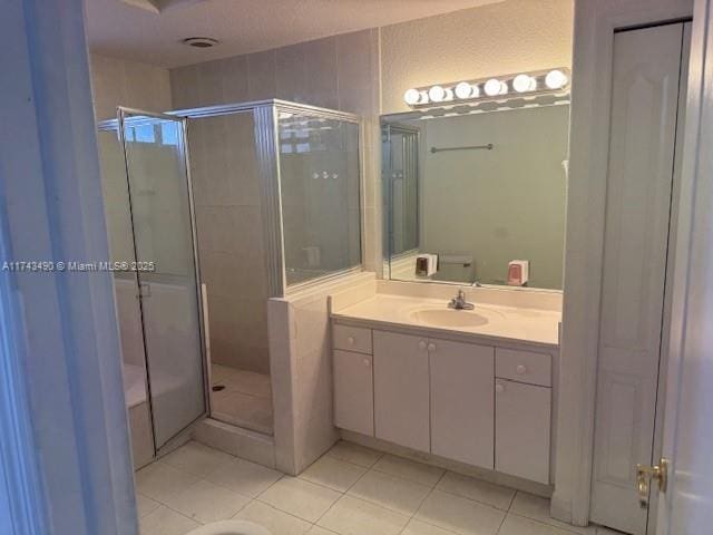 bathroom featuring vanity, tile patterned floors, a shower with door, and toilet