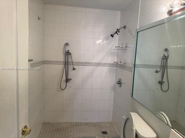 bathroom with tiled shower and toilet