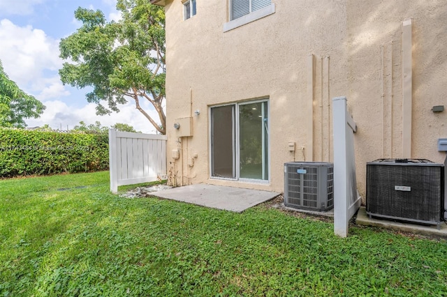 rear view of house with a patio, a lawn, and central air condition unit