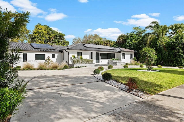 view of front facade featuring a front lawn and solar panels