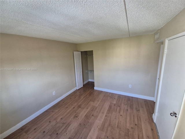 unfurnished bedroom with a closet, light hardwood / wood-style flooring, and a textured ceiling