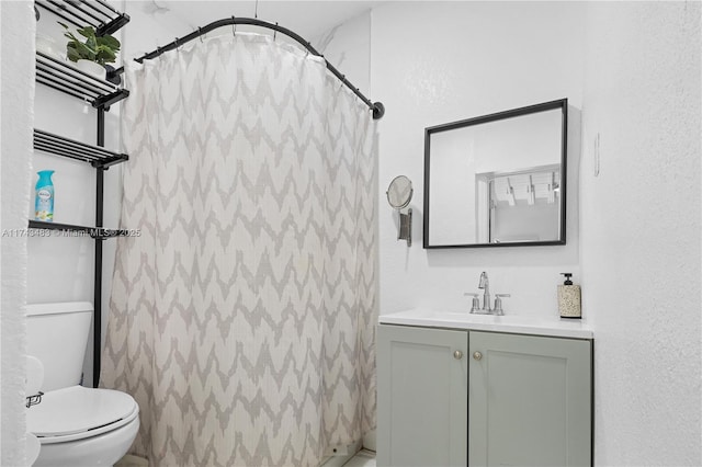 bathroom with vanity, a shower with shower curtain, and toilet