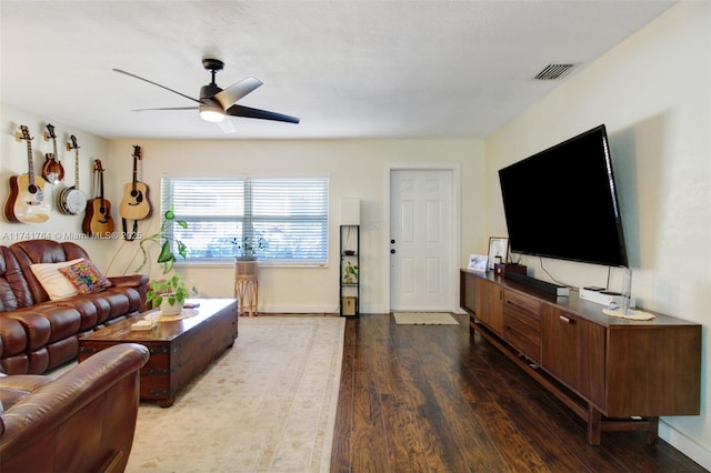 living room with dark wood-type flooring and ceiling fan