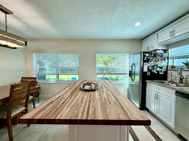 kitchen with white cabinetry, sink, plenty of natural light, and stainless steel appliances