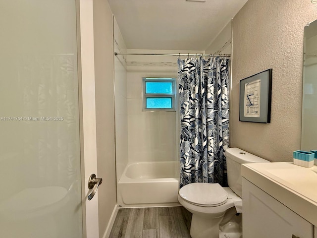 full bathroom with hardwood / wood-style flooring, vanity, shower / tub combo with curtain, and toilet