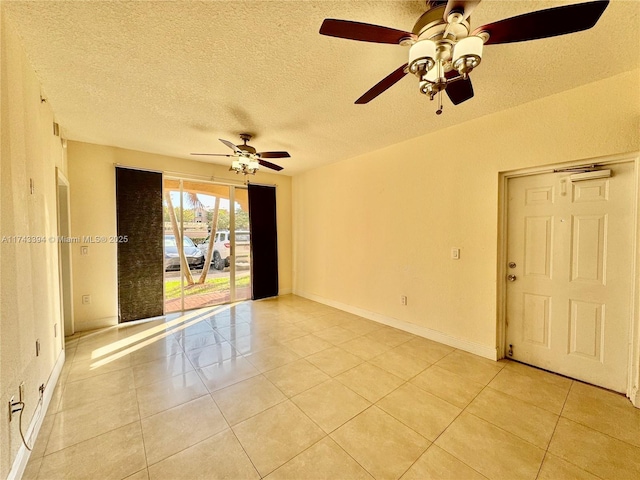 tiled empty room featuring a textured ceiling