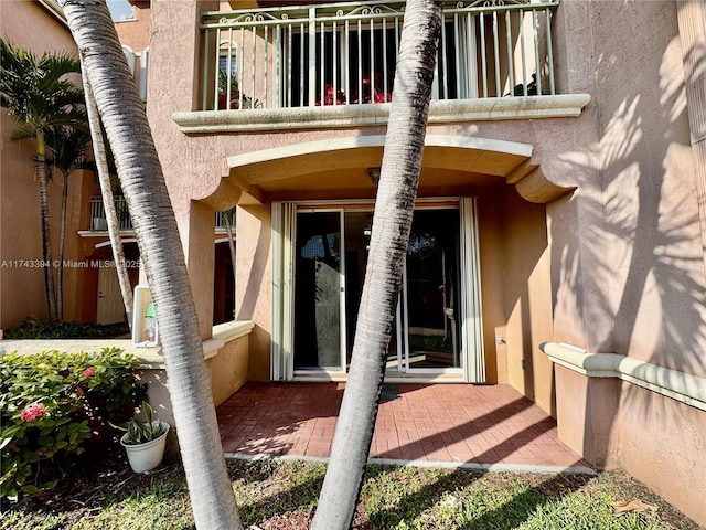 view of exterior entry featuring a balcony