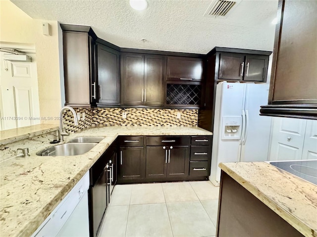 kitchen featuring dark brown cabinets, sink, backsplash, and white appliances