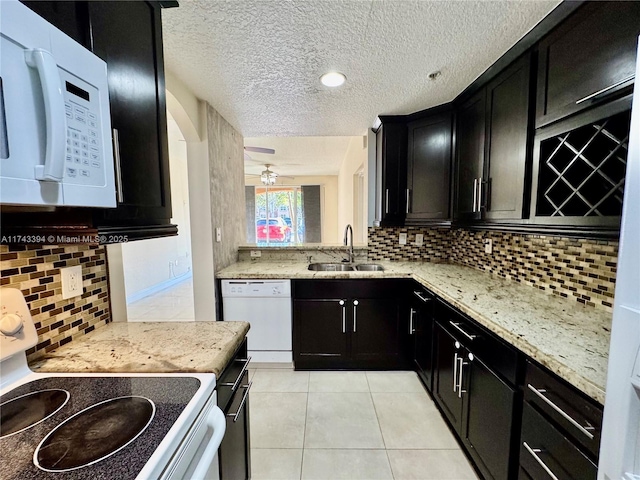 kitchen featuring light stone counters, sink, white appliances, and light tile patterned flooring