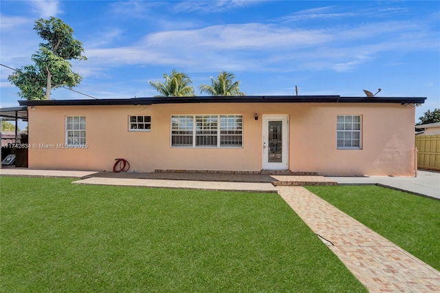 view of front of house featuring a front yard, fence, and stucco siding