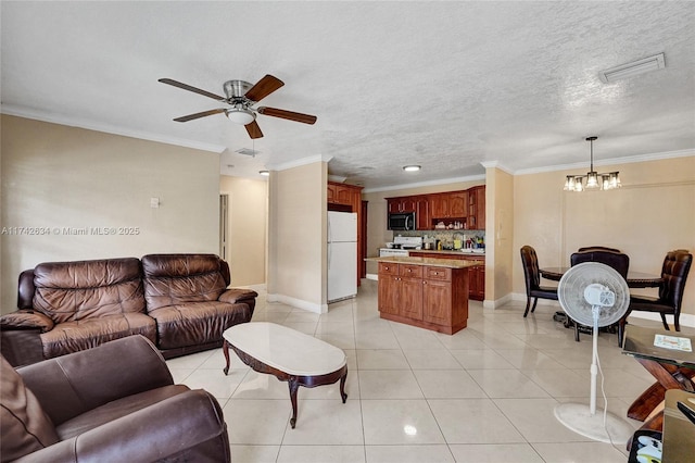 living room featuring a textured ceiling, light tile patterned flooring, visible vents, and crown molding