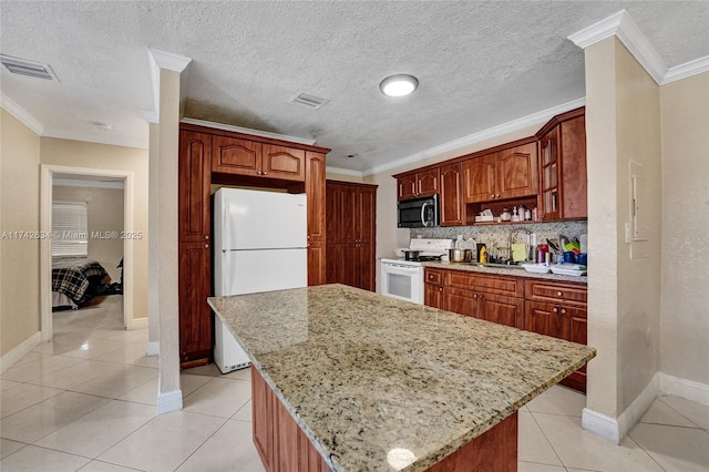 kitchen featuring visible vents, ornamental molding, light tile patterned flooring, light stone countertops, and white appliances