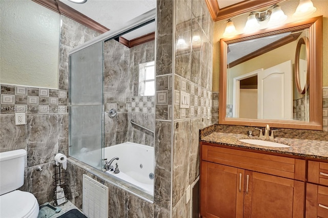 full bathroom with toilet, a combined bath / shower with jetted tub, crown molding, vanity, and tile walls