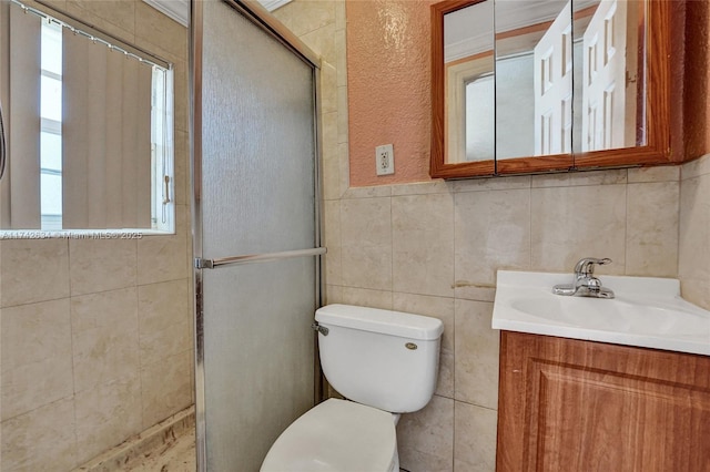 bathroom with a stall shower, tile walls, vanity, and toilet