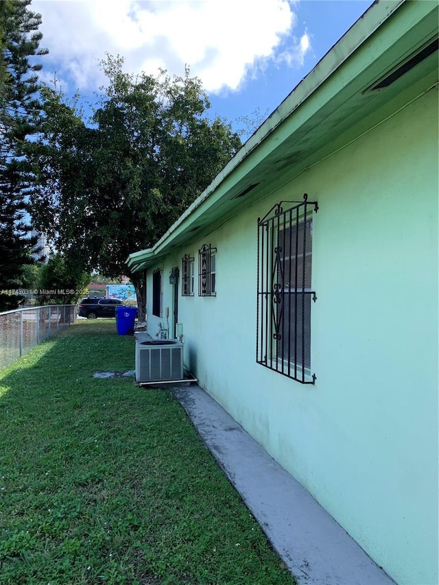 view of home's exterior featuring central AC unit and a lawn