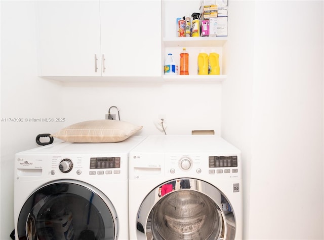 washroom featuring washing machine and dryer and cabinets