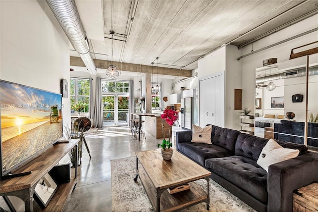 living area featuring concrete flooring and a towering ceiling