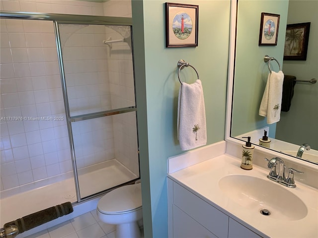 bathroom featuring tile patterned floors, toilet, an enclosed shower, and vanity