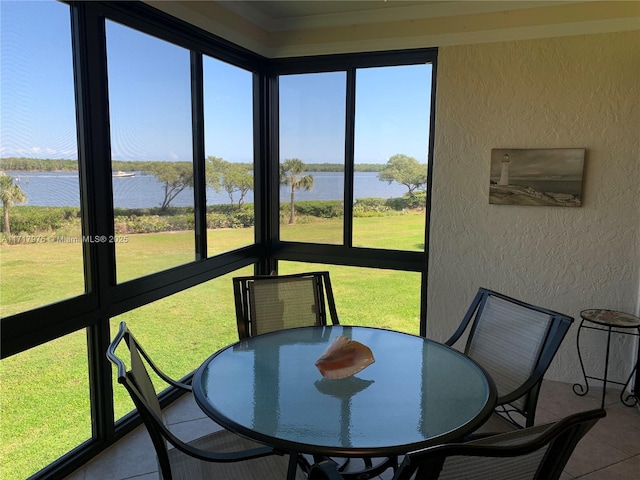 sunroom featuring a water view