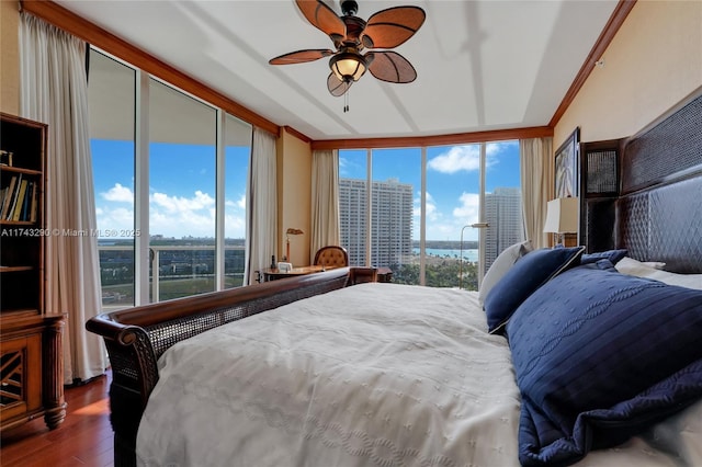 bedroom with expansive windows, wood finished floors, and a city view