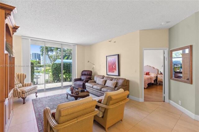 living room with expansive windows, a healthy amount of sunlight, light tile patterned floors, and a textured ceiling