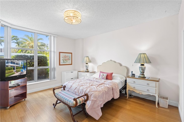 bedroom with a textured ceiling and light wood-type flooring