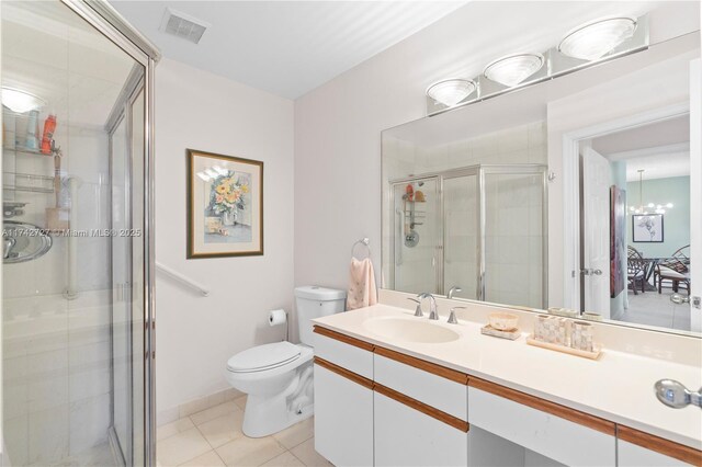 bathroom with vanity, tile patterned floors, a shower with door, and toilet