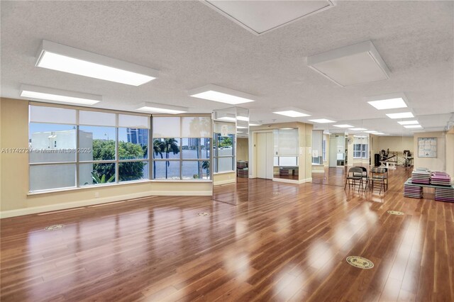 workout area with wood-type flooring and a textured ceiling