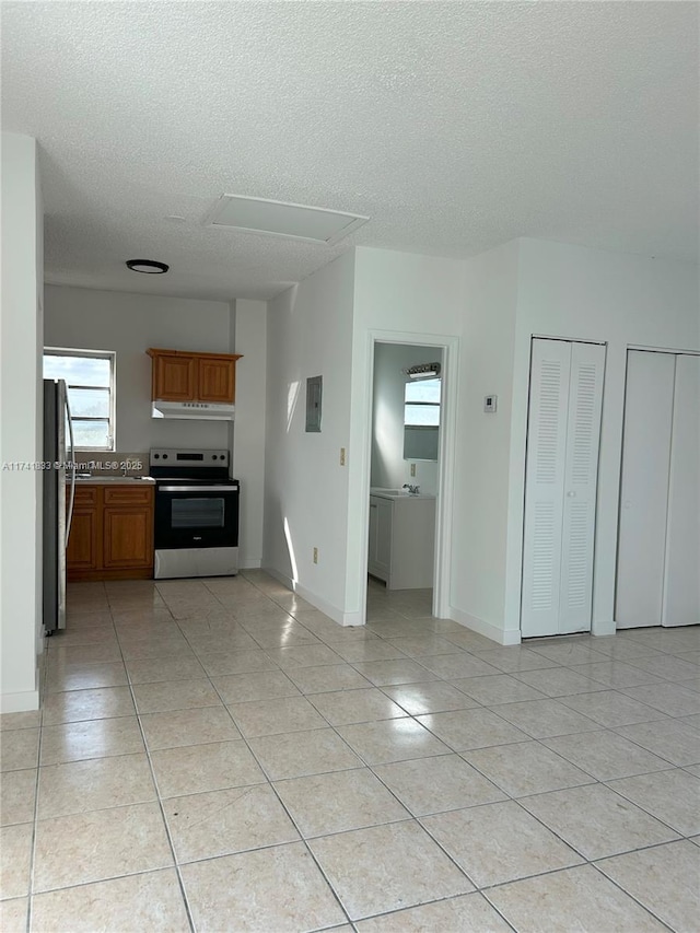 interior space with electric panel, a textured ceiling, and light tile patterned flooring