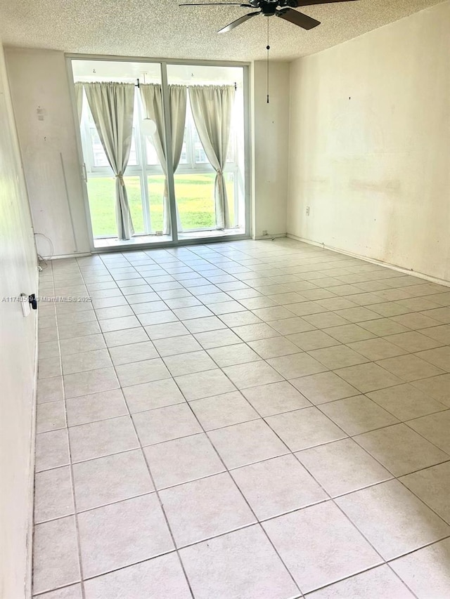 tiled spare room with ceiling fan and a textured ceiling