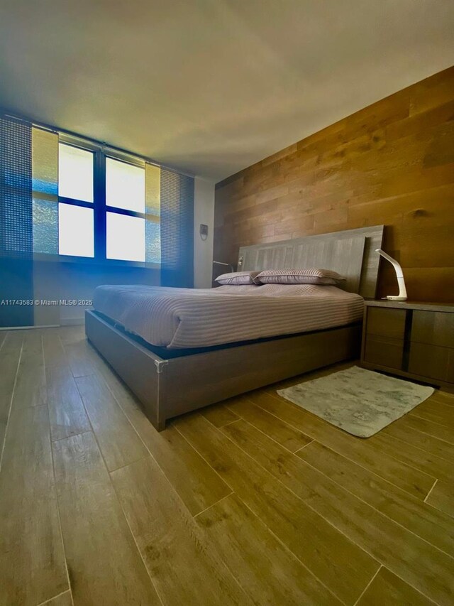 unfurnished bedroom featuring wood walls and hardwood / wood-style flooring