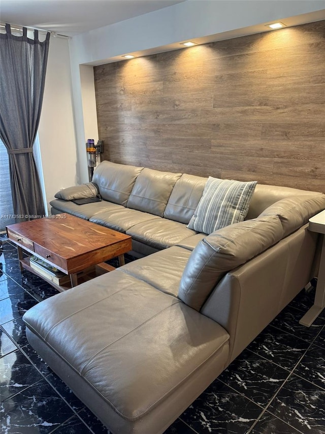 living area featuring marble finish floor and wood walls