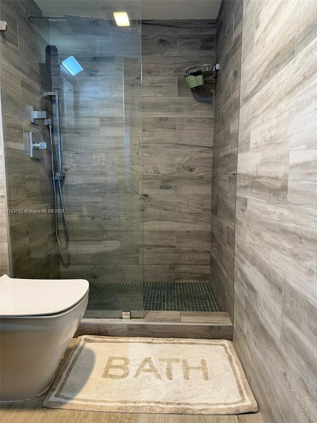 bathroom featuring toilet and a tile shower