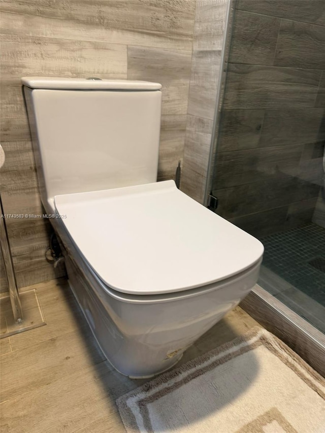 interior details with a shower stall and wood finished floors