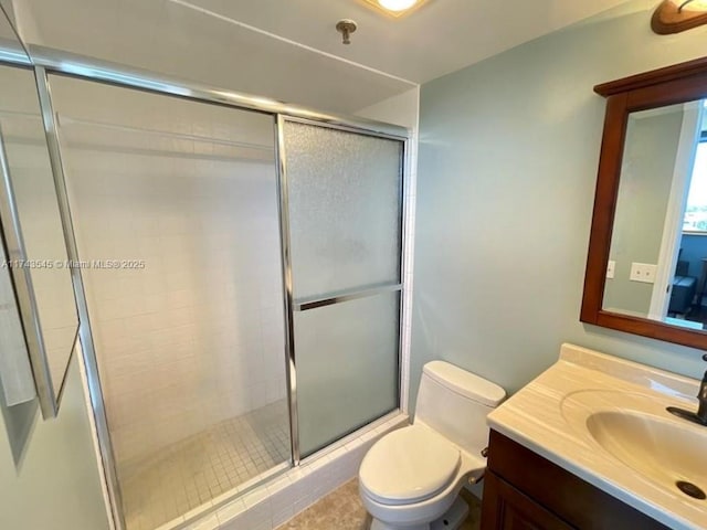 bathroom featuring vanity, walk in shower, and toilet