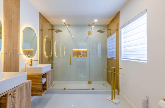 bathroom featuring a shower with door and vanity