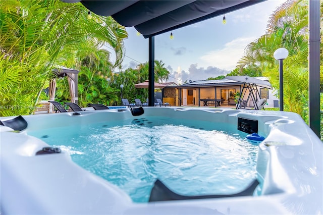 view of pool featuring a gazebo and a hot tub