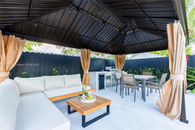 view of patio with area for grilling, an outdoor living space, and a gazebo