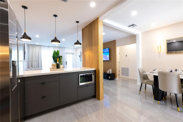 kitchen with stainless steel appliances and decorative light fixtures