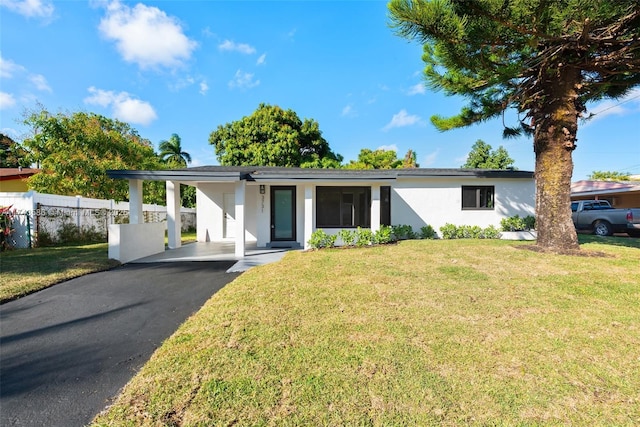 ranch-style house featuring a carport and a front yard