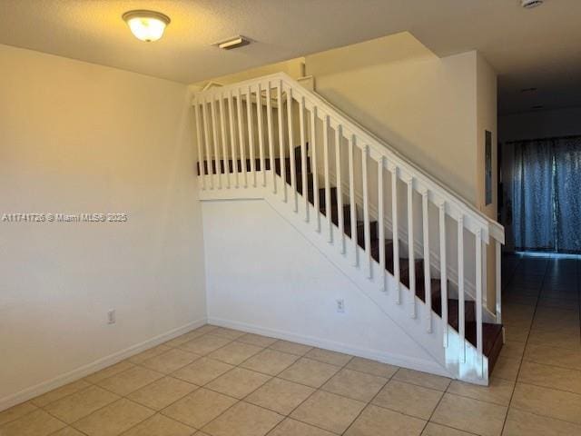 stairs featuring tile patterned flooring