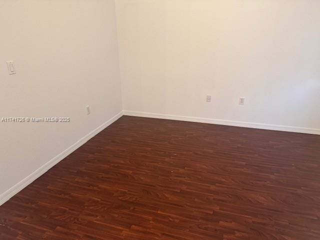 unfurnished room with dark wood-type flooring